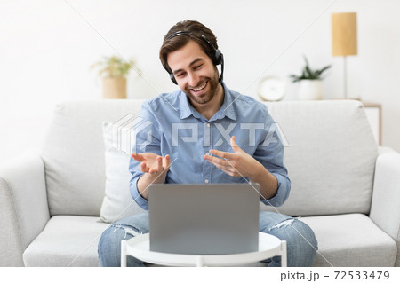 Cheerful Guy In Headset Making Video Call Via Laptop Indoor Cheerful Guy In Headset Making Video Call Via Laptop Indoor 72533479