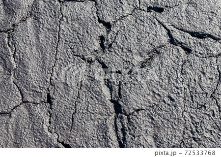 Texture of wet cracked ground as background 72533768