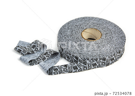 elastic knitted tape yarn for crochet on white background rolled up. 72534078