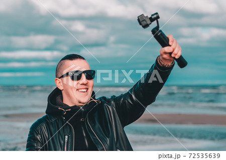 Young Male Hipster Making Selfie Using Action Camera 72535639