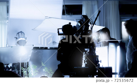 Silhouette images of video production behind the scenes or b-roll or making of TV commercial movies that film crew team lightman and videos cameraman working together with movie director in studio. 72535672