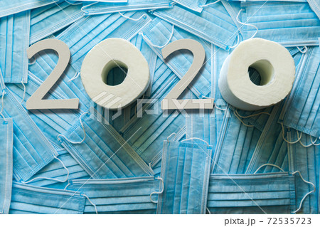 Background of a lot of medical masks and 2020 from white wooden numbers and toilet paper. Background of a lot of medical masks and 2020 from white wooden numbers and toilet paper. 72535723