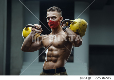 Caucasian man exercising in gym wearing a mask Caucasian man exercising in gym wearing a mask 72536285