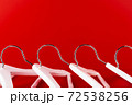 White hangers on a red background. Sales clothes concept. 72538256
