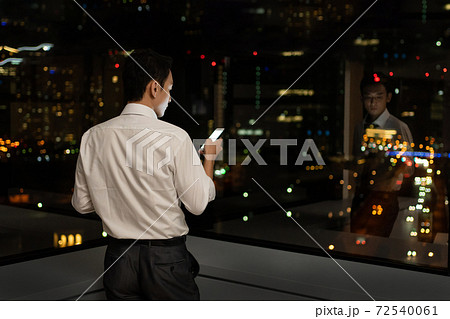 オフィスで夜遅くまで残業をするビジネスマン 72540061