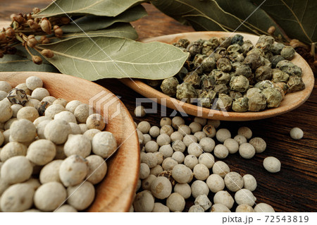 White peppercorn spice heap on wooden table 72543819