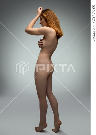 Young naked slim woman touching hair and cover breast 72547030