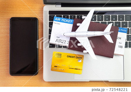 Smartphone near laptop computer and airplane on table. Online ticket booking concept Smartphone near laptop computer and airplane on table. Online ticket booking concept 72548221