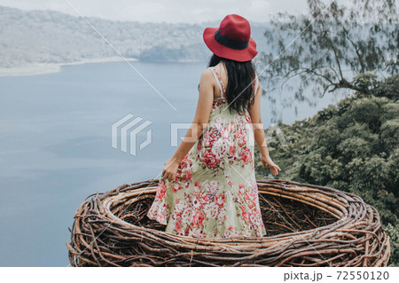 Pretty Asian woman is sitting on straw nest, Wanagiri hidden hill, Bali. Pretty Asian woman is sitting on straw nest, Wanagiri hidden hill, Bali. 72550120