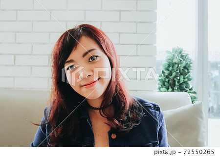 Young pretty Asian woman sitting in the cafe with nature light. 72550265