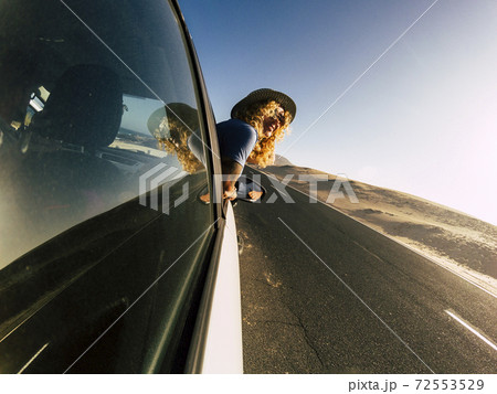 Happy traveler caucasian adult woman outside the car looking the beautiful landscape - active people and transportation concept - summer drive activity and wanderlust lifestyle people 72553529