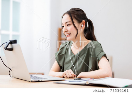 自宅でビデオチャットをする若い女性の写真素材