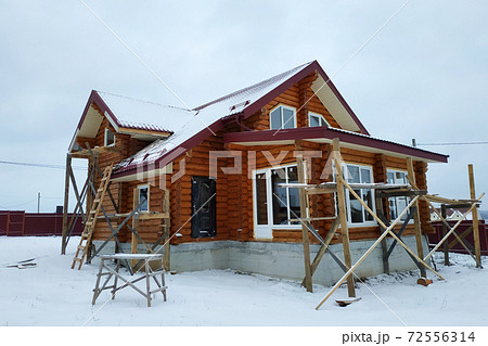 Beautiful unfinished wooden house with round logs in the countryside 72556314