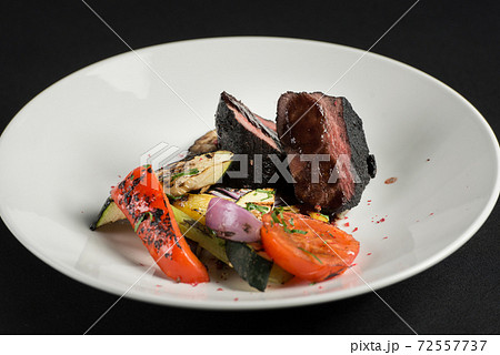 veal tenderloin in ashes with grilled vegetables on a white plate veal tenderloin in ashes with grilled vegetables on a white plate 72557737