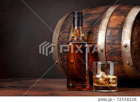 Scotch whiskey bottle, glass and old barrel 72558226