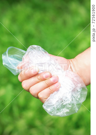 Hand holds crumpled plastic debris 72561900