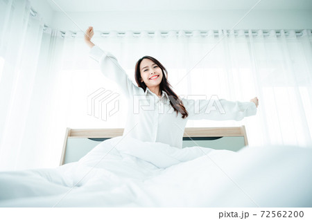 Beautiful women asian wake up in morning in bedroom. She is stretching and feeling fresh Beautiful women asian wake up in morning in bedroom. She is stretching and feeling fresh 72562200