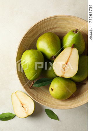 Bowl with green pears on white textured background 72562754