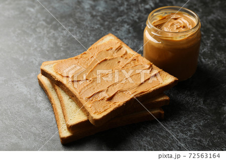 Concept of breakfast with peanut butter toast on black smokey table 72563164