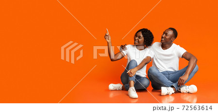 Happy black lovers looking together at copy space Happy black lovers looking together at copy space 72563614