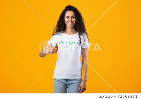Cheerful Volunteer Lady Gesturing Thumbs Up Standing Over Yellow Background 72563871