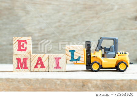 Toy forklift hold letter block l to complete word e mail on wood background 72563920