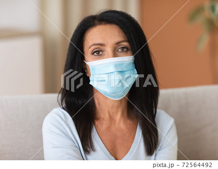 Portrait of mature woman wearing disposable mask to prevent infection Portrait of mature woman wearing disposable mask to prevent infection 72564492