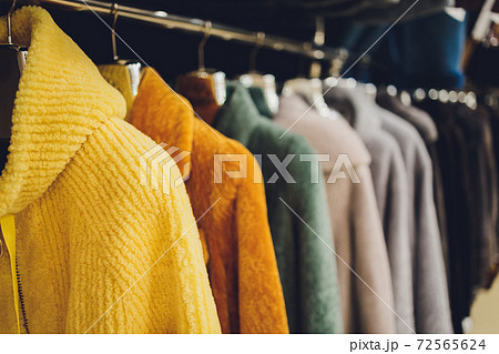 Coats and jackets on hangers in the store. Sale of outerwear. 72565624