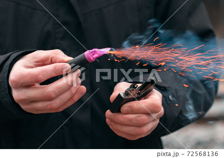 Firecracker Burning in Hand with Sparks and Smoke Firecracker Burning in Hand with Sparks and Smoke 72568136