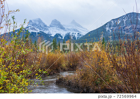 Snow capped The Three Sisters trio peaks mountain in autumn. Beautiful natural scenery landscape at Canmore, Canadian Rockies, Alberta, Canada. Snow capped The Three Sisters trio peaks mountain in autumn. Beautiful natural scenery landscape at Canmore, Canadian Rockies, Alberta, Canada. 72569964
