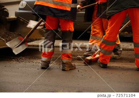 Road works with men in uniform working with tools Road works with men in uniform working with tools 72571104