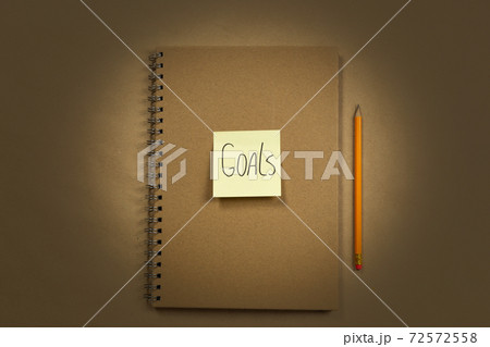 Brown Notebook with yellow sticky note top view for Goal or to do list notepad, brown background texture, copy space, business or education concept Brown Notebook with yellow sticky note top view for Goal or to do list notepad, brown background texture, copy space, business or education concept 72572558
