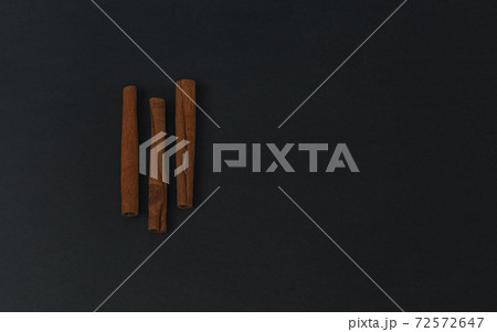 Cinnamon sticks on black background, flatlay in dark key 72572647