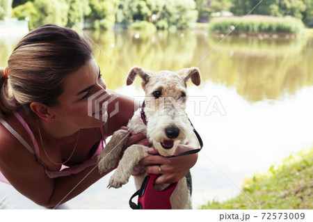 pretty woman with cute dog fox terrier playing in green sunny park, lifestyle people concept 72573009