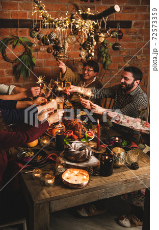 Family burning sparklers and feasting over Family burning sparklers and feasting over 72573359