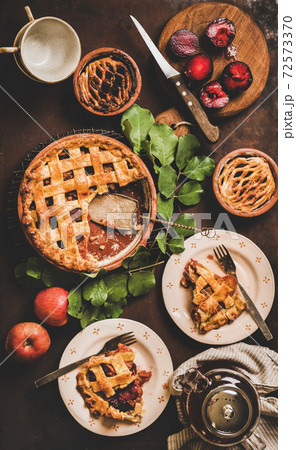 Flat-lay of apple and plum pie on rack with tea Flat-lay of apple and plum pie on rack with tea 72573370