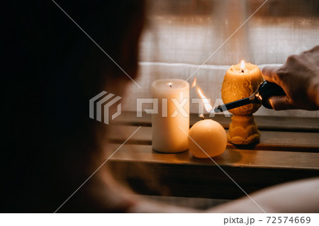 Young woman sitting on the floor, lights candles, enjoy meditation, do yoga exercise at home. Mental health, self care, No stress, healthy habit, mindfulness lifestyle, anxiety relief concept Young woman sitting on the floor, lights candles, enjoy meditation, do yoga exercise at home. Mental health, self care, No stress, healthy habit, mindfulness lifestyle, anxiety relief concept 72574669