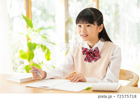 リビングで勉強をする中学生の女の子の写真素材