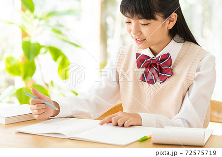 リビングで勉強をする中学生の女の子の写真素材