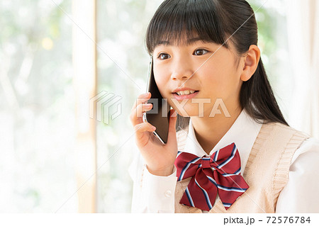 リビングでスマホを使う制服の女の子 72576784