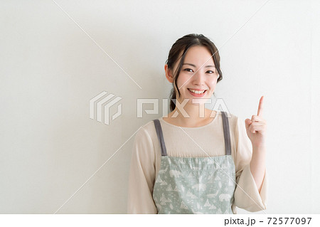 エプロンの若い女性 指差し エプロンの若い女性 指差し 72577097