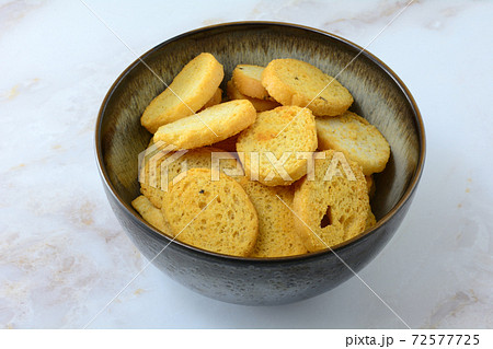 Italian black pepper and prosciutto ham flavored bread bites in ceramic bowl on table Italian black pepper and prosciutto ham flavored bread bites in ceramic bowl on table 72577725