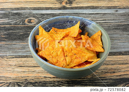 Taco flavored corn tortilla chips in ceramic snack bowl in table Taco flavored corn tortilla chips in ceramic snack bowl in table 72578082