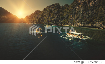 Seascape with passenger boats at sunset in closeup aerial view. Cliff coast with trees at sun summer 72578495