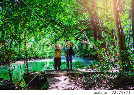 Travelers, couples with natural travel backpacks during the holidays. Couples traveling, relaxing in greens jungle and enjoying the beautiful Emerald pond. Tourism, hiking, nature study. Travelers, couples with natural travel backpacks during the holidays. Couples traveling, relaxing in greens jungle and enjoying the beautiful Emerald pond. Tourism, hiking, nature study. 72579371