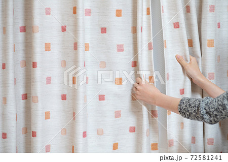 子供部屋のカーテンを閉める女性の手の写真素材