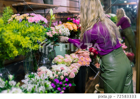 young woman florist standing and working in flower shop young woman florist standing and working in flower shop 72583333