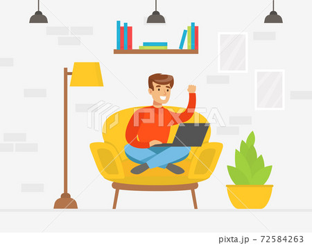 Smiling Young Man Sitting in Cozy Armchair and Playing Laptop Computer Cartoon Vector Illustration 72584263