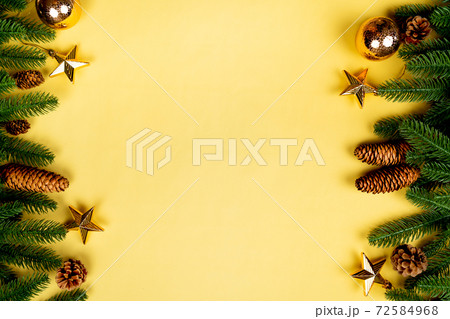 Christmas background, pine tree with xmas decoration on yellow background Christmas background, pine tree with xmas decoration on yellow background 72584968