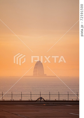 早朝の羽田空港 滑走路から朝焼けの東京湾風の塔 川崎人工島 の写真素材